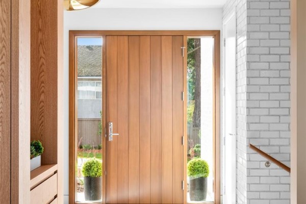Close-up of the wooden front door with sidelights and potted plants - 4570 Bissenden Pl, Saanich