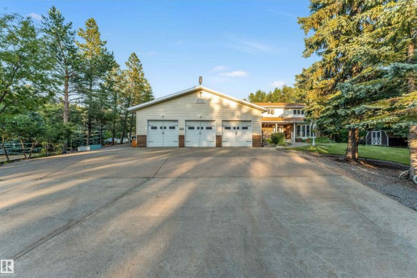 Two-story house with attached garage and manicured lawn under a blue sky. - #458 23109 Twp Road 514, Rural Strathcona County