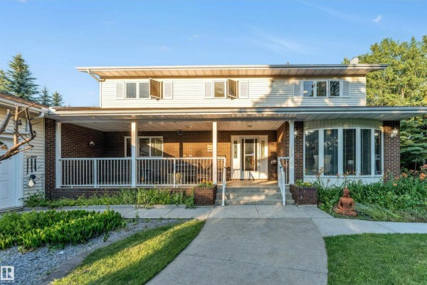 Exterior view of a cream-colored house with a three-bay garage and driveway. - #458 23109 Twp Road 514, Rural Strathcona County