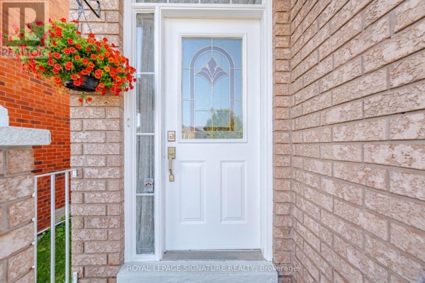Close-up of the white front door with glass panels and a hanging flower basket. - 459 Wildgrass Road, Mississauga