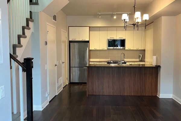 Modern kitchen with stainless steel appliances, white cabinetry, and dark wood island. - 46 - 23 Valhalla Inn Road, Toronto