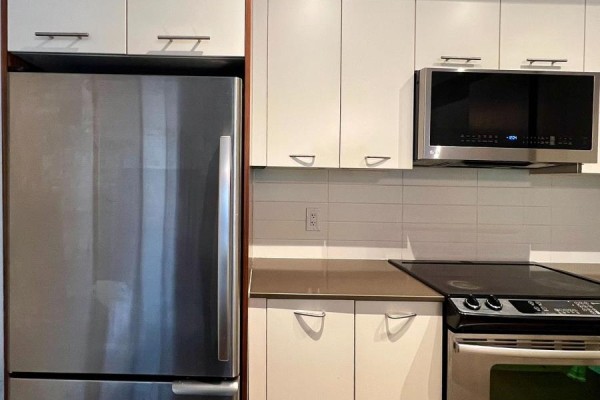Close-up view of a stainless steel refrigerator, white cabinets, and microwave. - 46 - 23 Valhalla Inn Road, Toronto