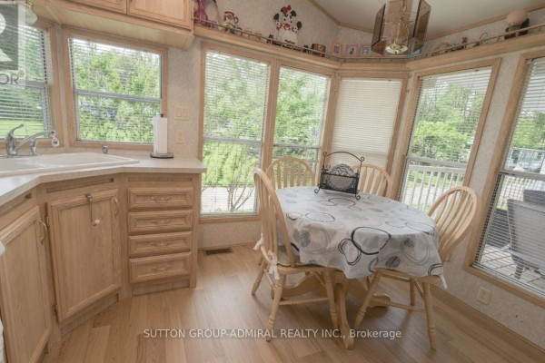 Dining area with a round table and chairs next to a bay window. - 46 - 497 County Rd 36 Road, Trent Lakes