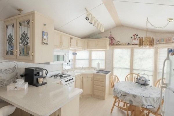 Corner kitchen with light wood cabinets, a gas stove, and a small dining table. - 46 - 497 County Rd 36 Road, Trent Lakes