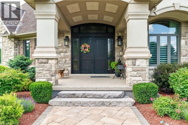 Close-up of a double front door entrance with stone columns, a covered porch, and manicured landscaping. - 46 Anita Drive, St  Clements
