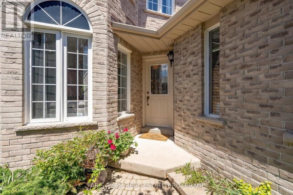 Close-up of the front entrance of a brick house with an arched window and beige door. - 46 Bell Street, Barrie