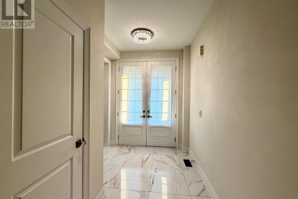Living room with dark hardwood floors, white walls, a fireplace, and a mounted television. - 46 Haskins Crescent, Georgina