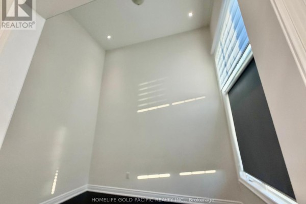 Bathroom with a glass shower, white vanity, toilet, and mirrored sconces. - 46 Haskins Crescent, Georgina