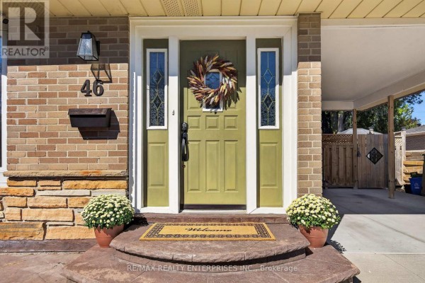 Close-up of the front door entrance featuring a green door with stained glass sidelights and a wreath. - 46 Marilyn Crescent, Halton Hills