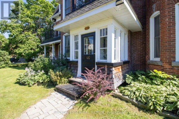 Close-up of the front entrance with a black door, shingled siding, and mature landscaping. - 46 Quabbin Road, Front Of Yonge