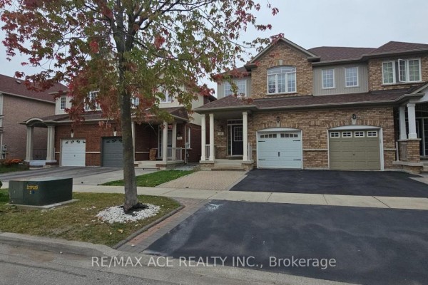Street view of townhouses with stone and brick facades and garages. - 46 Ralph Chalmers Avenue, Markham