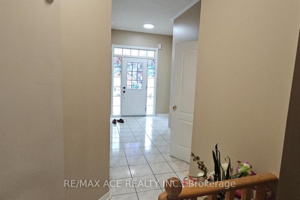 View from foyer looking towards a glass-paneled front door with tiled floor. - 46 Ralph Chalmers Avenue, Markham