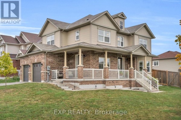 Side view of a two-story house with brick and vinyl siding, a covered porch, and a garage. - 46 Rennie Street, Brock