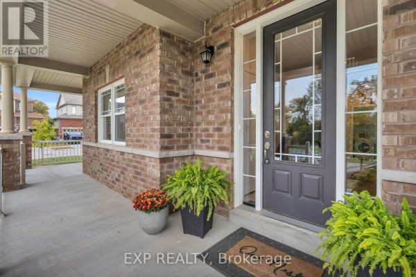 Close-up of a front door with sidelights and transom window, surrounded by brickwork and potted plants. - 46 Rennie Street, Brock