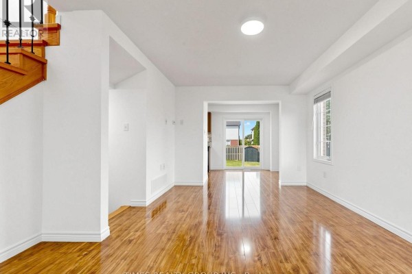 View of the living room and dining area, with a sliding glass door to the backyard. - 46 Ridwell Street, Barrie