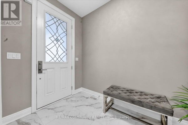 Foyer with a modern bench, marble flooring, and decorative wall. - 46 Wamsley Crescent, Clarington
