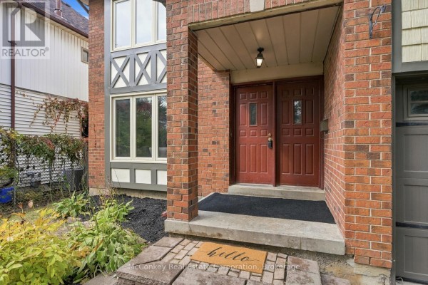 Close-up of the brick entrance to a house with double red doors. - 460 Cardinal Drive, Peterborough