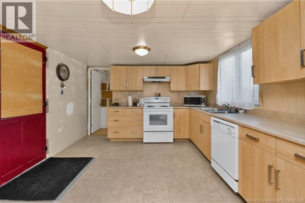 Kitchen with beige tiled floors, light wood cabinets, white appliances, and a red door on the left side. - 460 Middlesex, Colpitts Settlement