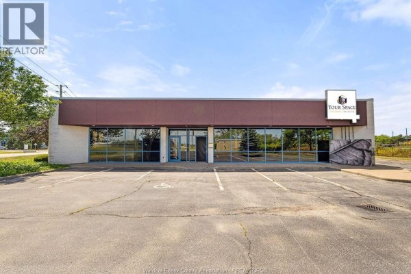 Corner view of a commercial building with a parking lot and blue sky. - 4600 Rhodes Drive Unit# #4 Office, Windsor