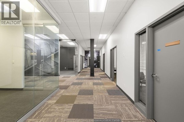 Commercial building facade with multiple business signs and large windows. - 4600 Rhodes Drive Unit# #4 Office, Windsor