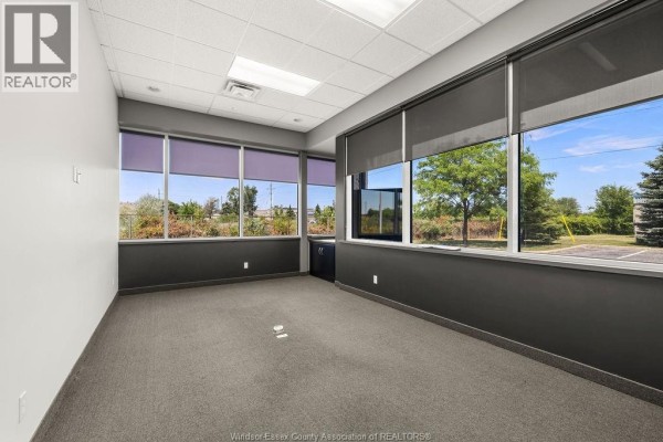 Exterior of a commercial building with a parking lot and landscaping. - 4600 Rhodes Drive Unit# #4 Office, Windsor