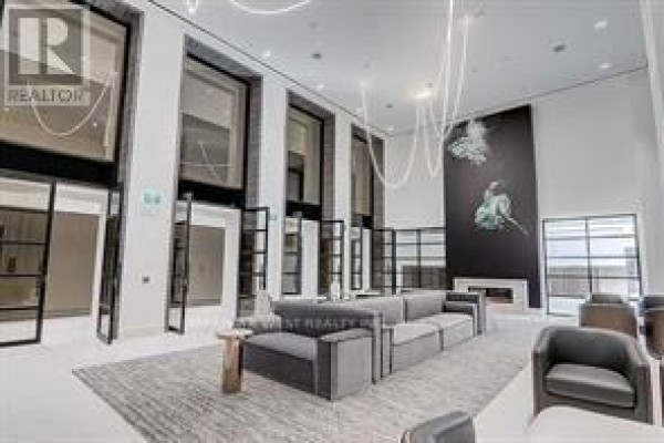 Living room with large windows, city views, a grey sofa, and a patterned rug. - 4603 - 39 Roehampton Avenue, Toronto