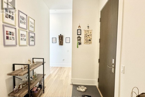 Open concept living and kitchen area with a white island, television, and modern white cabinets. - 4603 - 39 Roehampton Avenue, Toronto