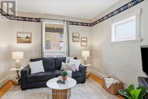 Living room with a sofa, marble coffee table, and a large window. - 461 Murray Street, Peterborough