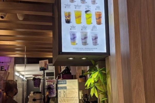 Interior view of counter with staff preparing drinks and additional menu display - 461 Queen Street W, Toronto