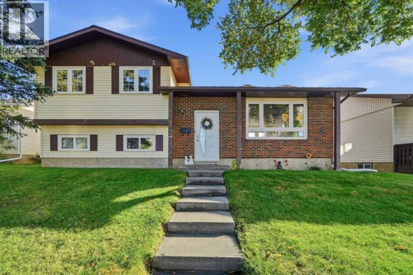 Front exterior view of a two-story house with brick and beige siding. - 4615 31 Avenue Ne, Calgary