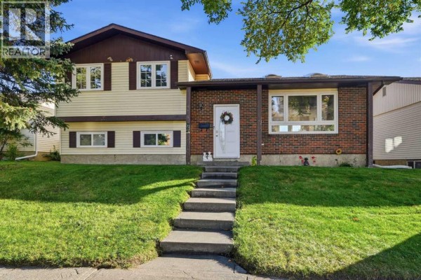 View of the house from the street showing the front entrance and lawn. - 4615 31 Avenue Ne, Calgary