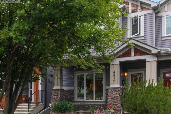 Covered front porch with stone pillars and a red front door. - 4616 82 Street Nw, Calgary