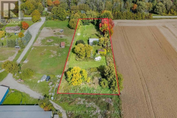 Aerial view of a large property with a house, outbuildings, and surrounded by fields. - 4617 Concession Road 2 Sunnidale, Clearview