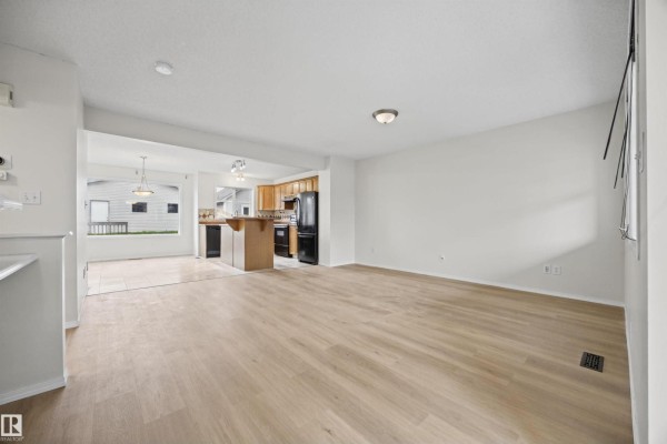 View from the living room into the entryway with stairs and a window. - 4618 Turner Square Sq Nw, Edmonton