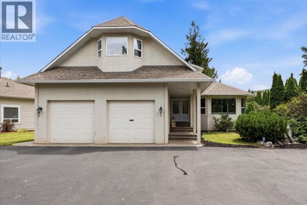 Front facade of the house showcasing a double garage, double front doors, and large side window. - 4619 Gordon Drive, Kelowna