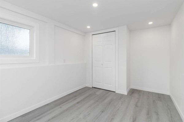 A white room with light grey wood-look flooring and a double closet under a frosted window. - 46190 Larch Avenue, Chilliwack Proper South, Chilliwack