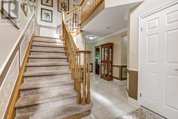 A finished basement with a bar, seating area, and wood-paneled walls. - 462 Ambleside Drive, London North