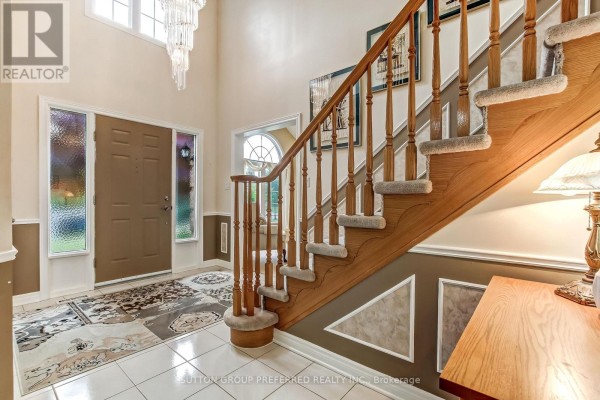 A bedroom with a king-size bed, vaulted ceiling, and arched window. - 462 Ambleside Drive, London North