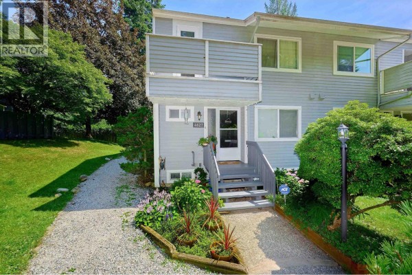 Front entrance of a townhouse with gray stairs and a white door. - 4627 Hoskins Road, North Vancouver