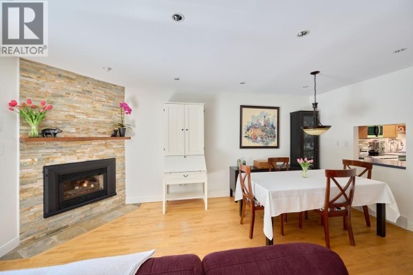 Family room with built-in cabinets, a sofa, a recliner, and a sliding glass door. - 4627 Hoskins Road, North Vancouver