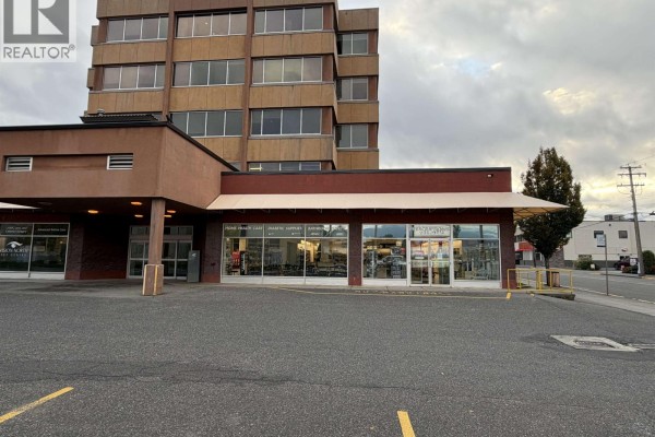 View of commercial building exterior with a tower structure behind retail spaces. - 4634 Park Avenue, Terrace