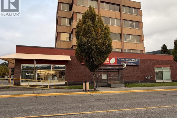 Side view of the commercial building, showing storefronts, entrance, and a bus shelter. - 4634 Park Avenue, Terrace