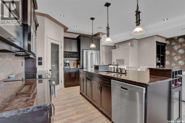 A bathroom with dark vanity, granite countertop, sink, toilet, and a shower curtain. - 4635 Ellard Court, Regina