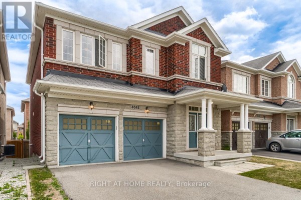 Front exterior view of the red brick house showing a double garage and entrance. - 4644 Doug Wright Drive, Burlington