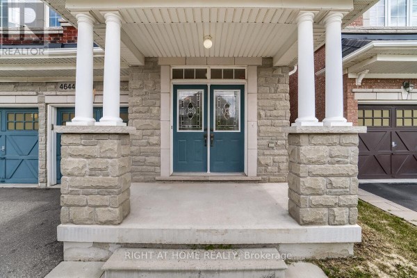Covered front porch with stone pillars and double glass-paneled teal doors. - 4644 Doug Wright Drive, Burlington