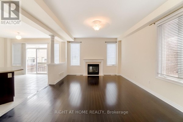 Living room with dark hardwood floors, cream walls, fireplace, and large windows. - 4644 Doug Wright Drive, Burlington