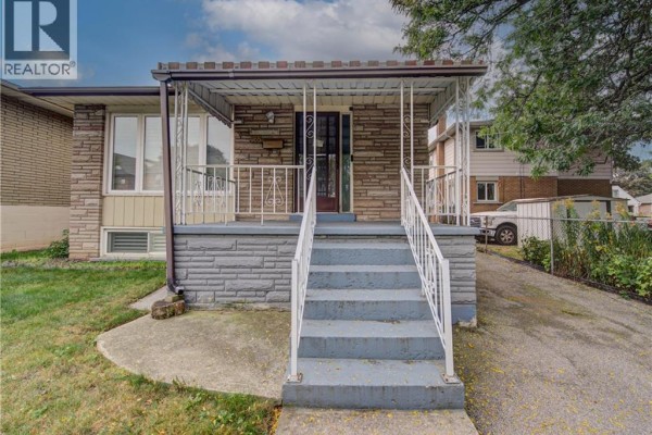 Close-up of the front porch stairs and entrance with light blue painted steps and gray stone facade. - 465 Herkimer Street, Hamilton