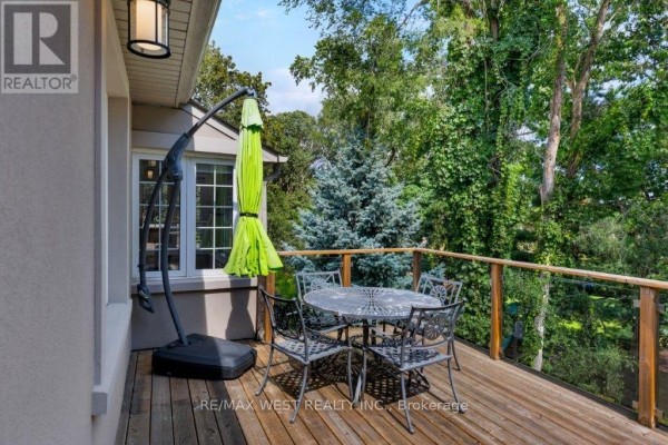 Outdoor dining set with umbrella on wood deck - 4653 Dundas Street W Toronto