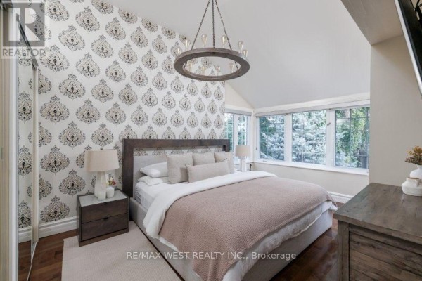 Bedroom with patterned wallpaper, large windows, and chandelier - 4653 Dundas Street W Toronto