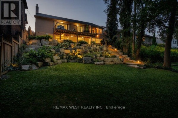 Backyard with deck, stone landscaping, and lawn - 4653 Dundas Street W Toronto